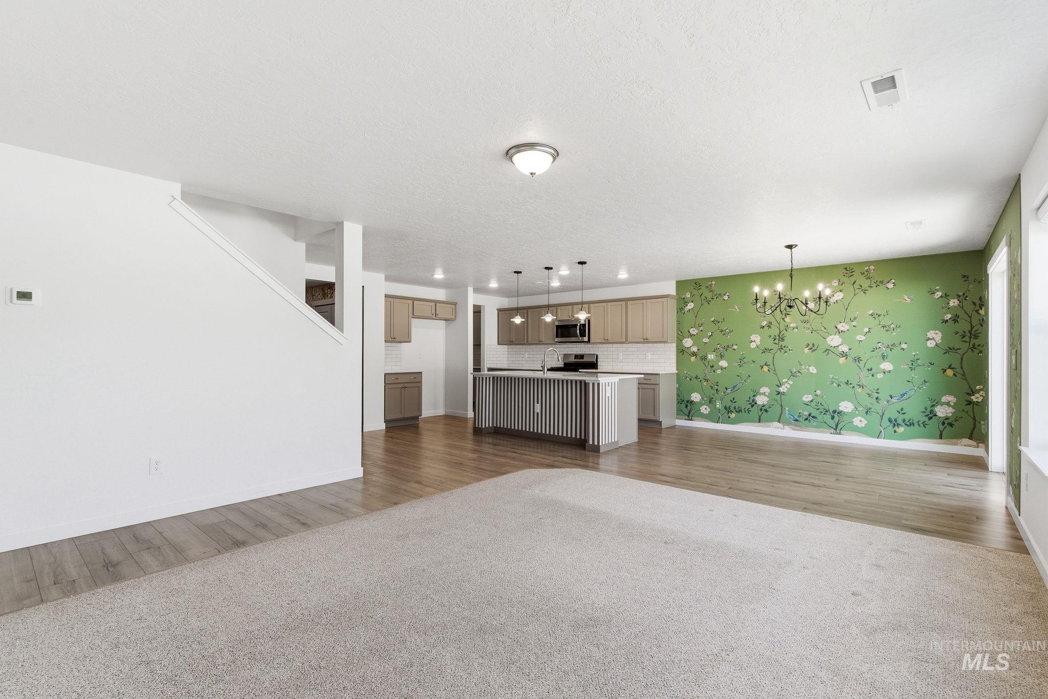 110 Homesteaders Street Middleton, ID 83644 - Photo 3 of 49 Unfurnished living room featuring hanging lights and dark carpet