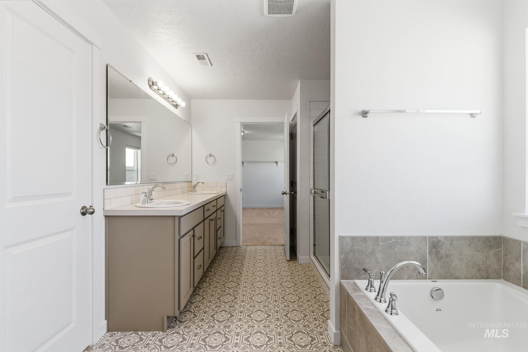110 Homesteaders Street Middleton, ID 83644 - Photo 39 of 49 Full bath with double vanity, a bath, and a shower stall