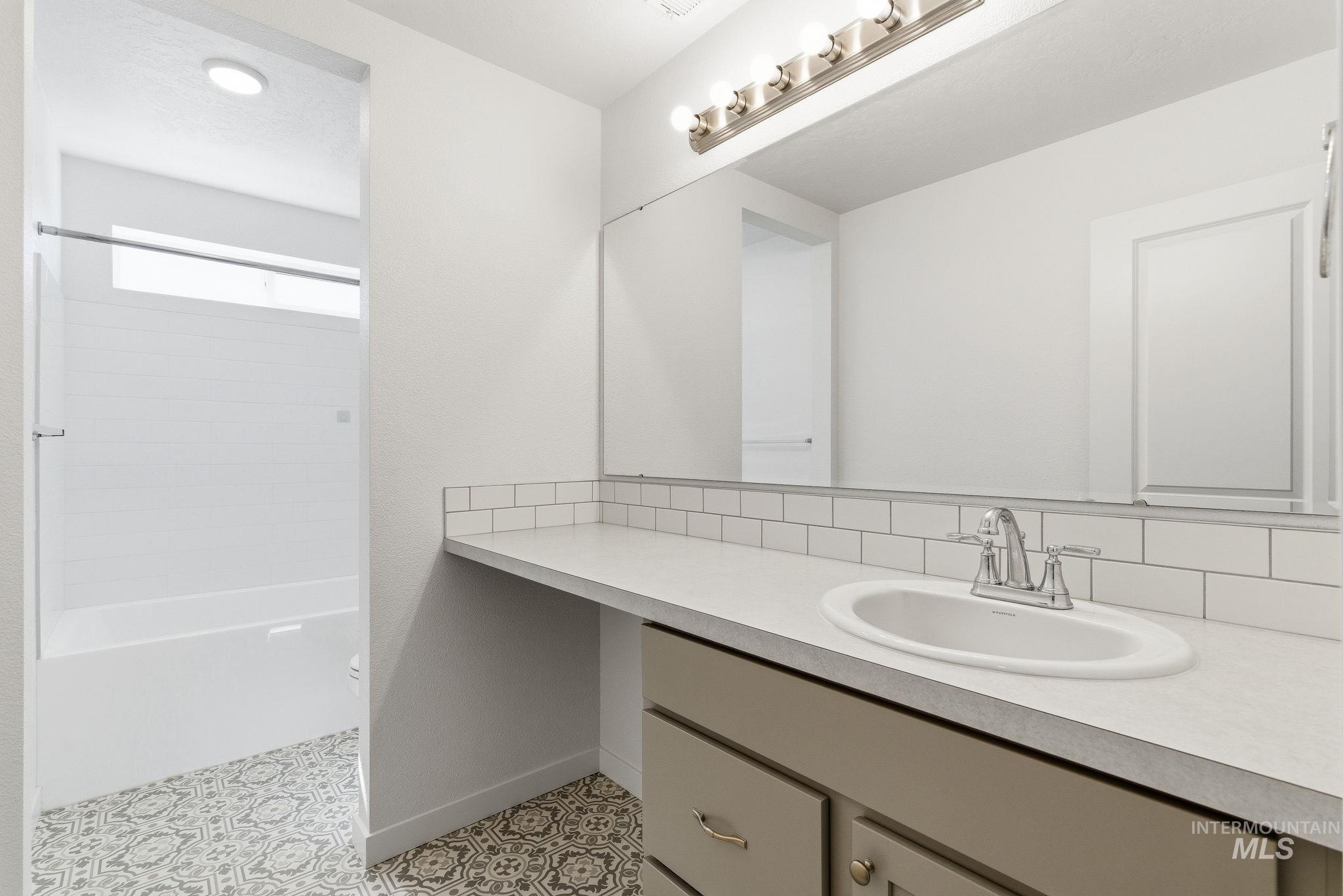 110 Homesteaders Street Middleton, ID 83644 - Photo 40 of 49 Full bathroom featuring vanity, light tile patterned floors, decorative backsplash, and tub / shower combination