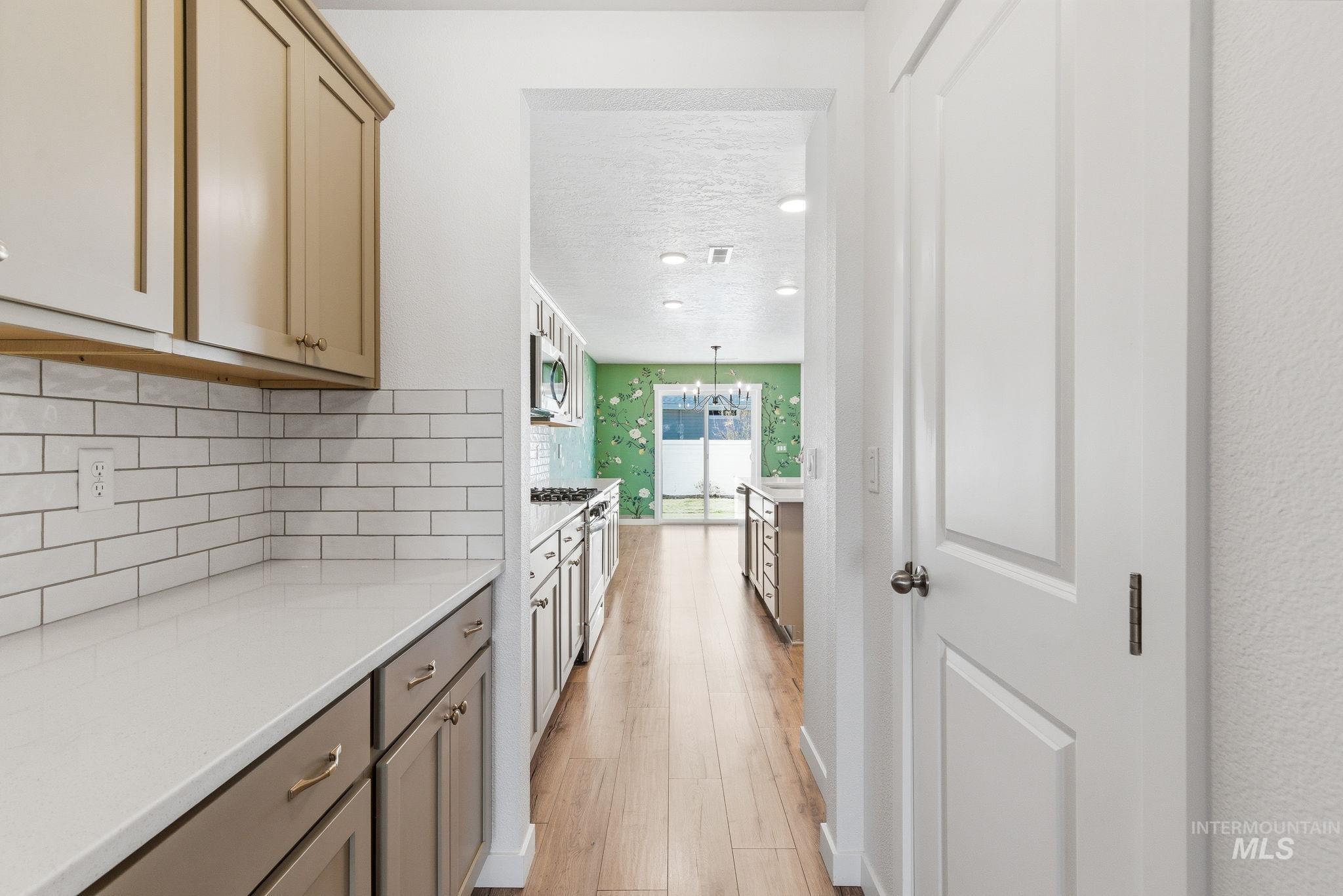 110 Homesteaders Street Middleton, ID 83644 - Photo 10 of 49 Hall with light wood finished floors, a textured ceiling, and hanging lights