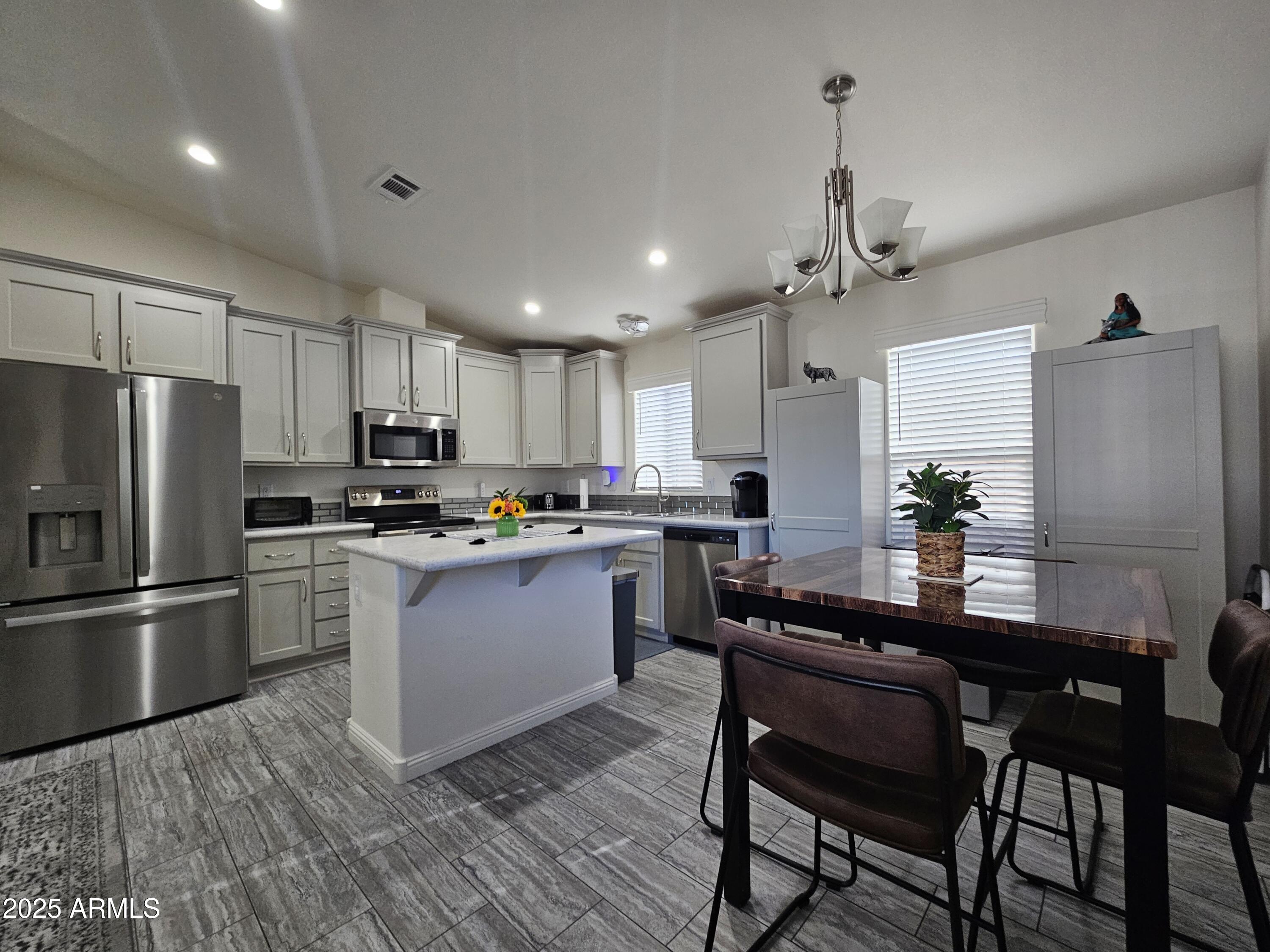 650 North Hawes Road, Unit 3124 Mesa, AZ 85207 - Photo 14 of 45 a kitchen with a refrigerator a sink dishwasher a stove and white cabinets with wooden floor