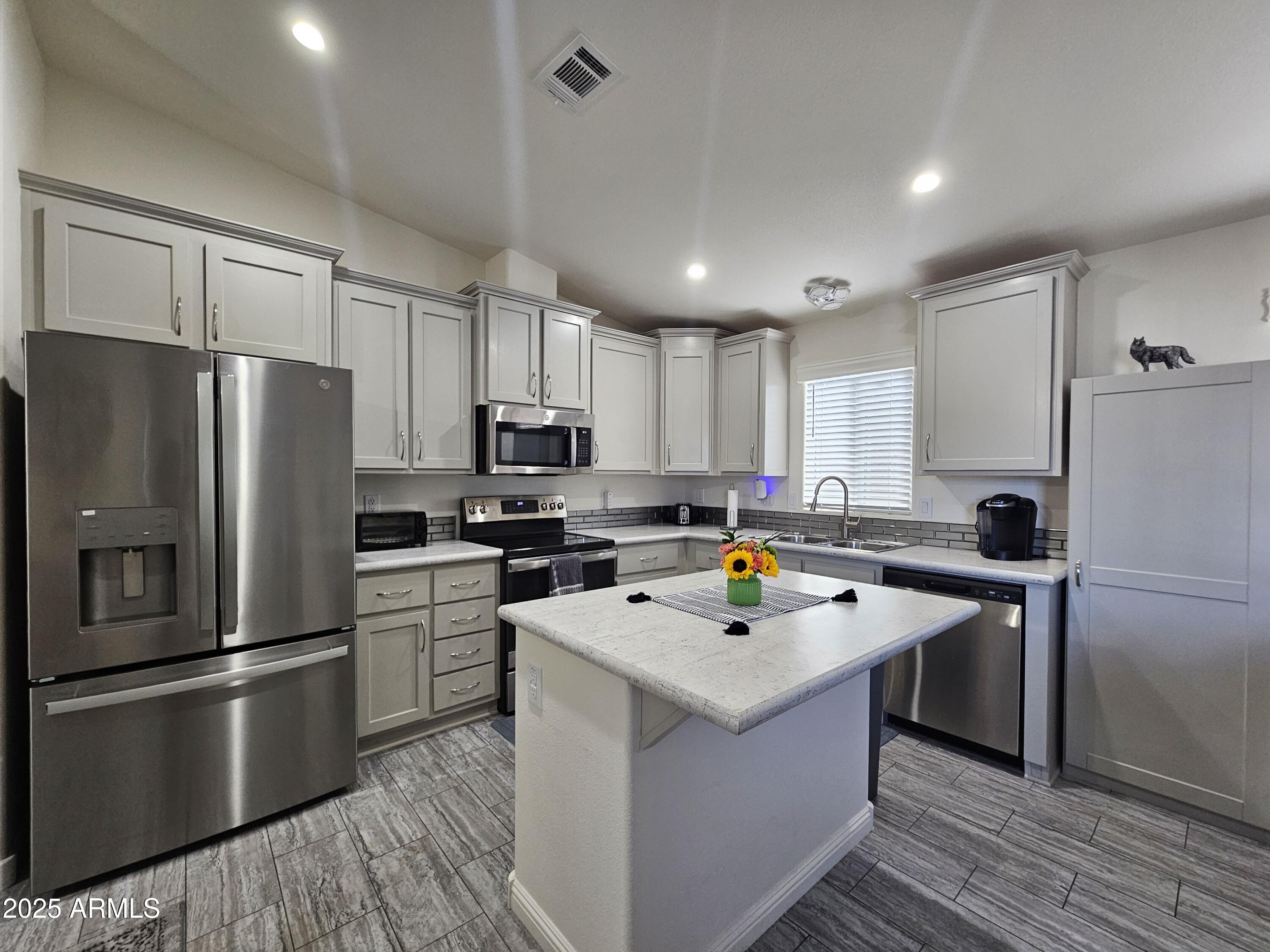 650 North Hawes Road, Unit 3124 Mesa, AZ 85207 - Photo 15 of 45 a kitchen with a refrigerator a sink and cabinets