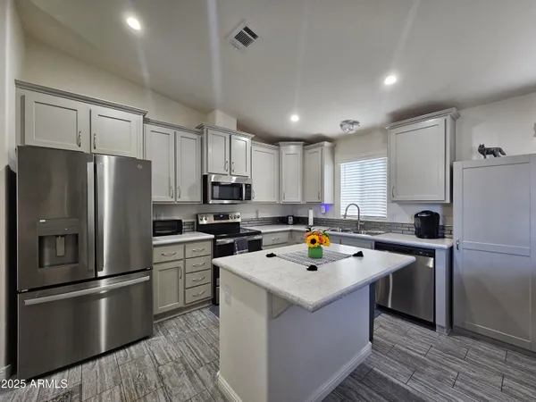 a kitchen with a refrigerator a sink and cabinets