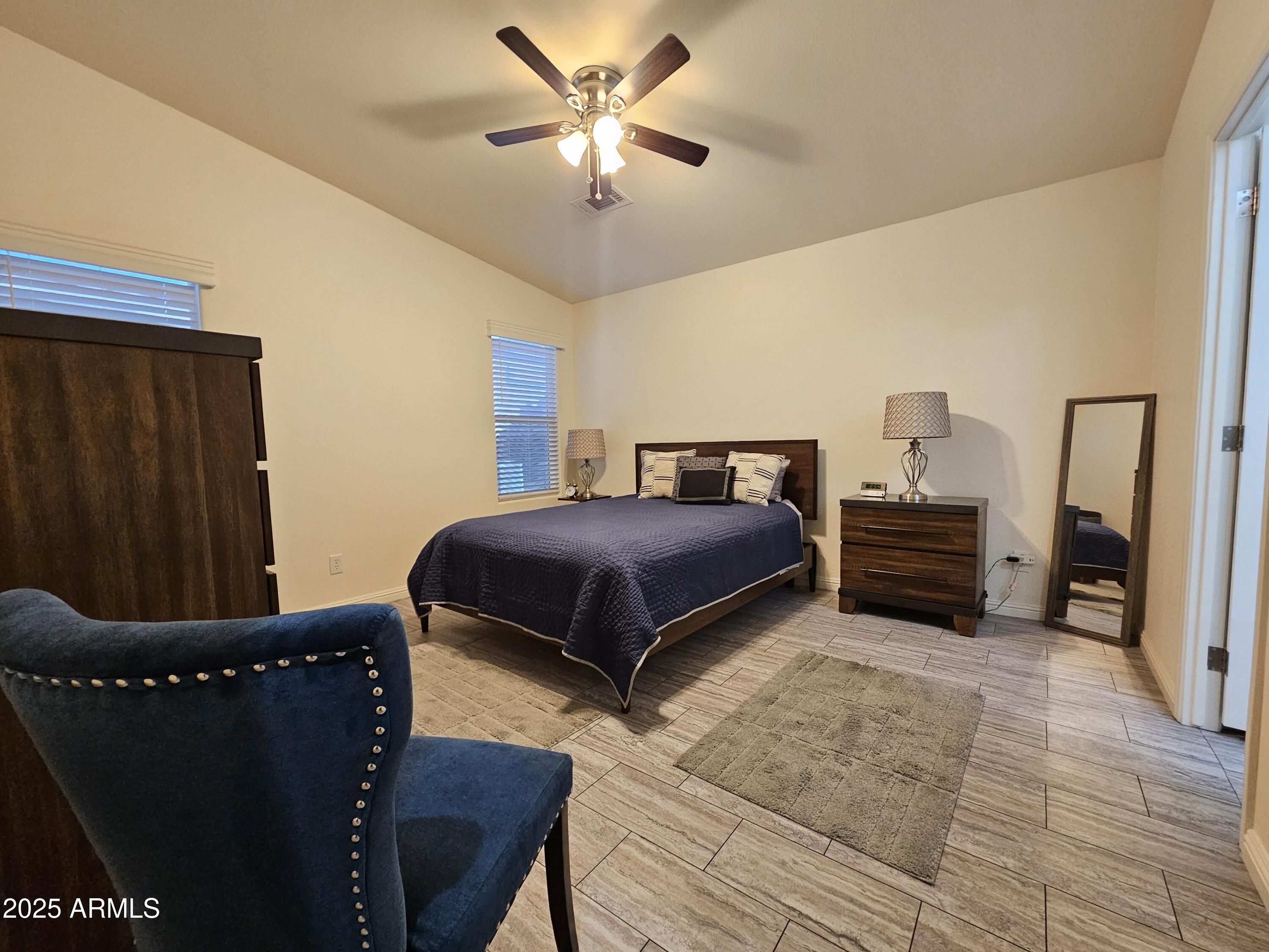 650 North Hawes Road, Unit 3124 Mesa, AZ 85207 - Photo 25 of 45 a bedroom with a bed and a chandelier