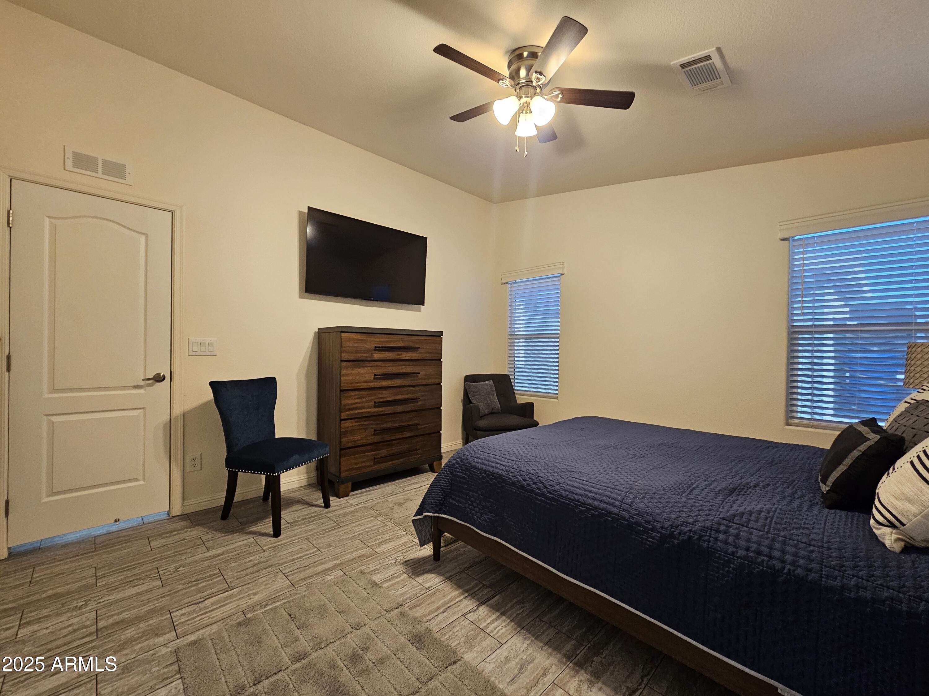 650 North Hawes Road, Unit 3124 Mesa, AZ 85207 - Photo 26 of 45 a bedroom with a bed and a chair with the potted plant