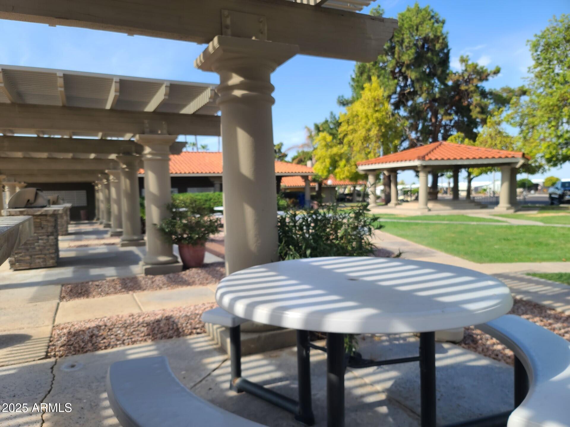 650 North Hawes Road, Unit 3124 Mesa, AZ 85207 - Photo 42 of 45 a view of a patio with table and chairs under an umbrella