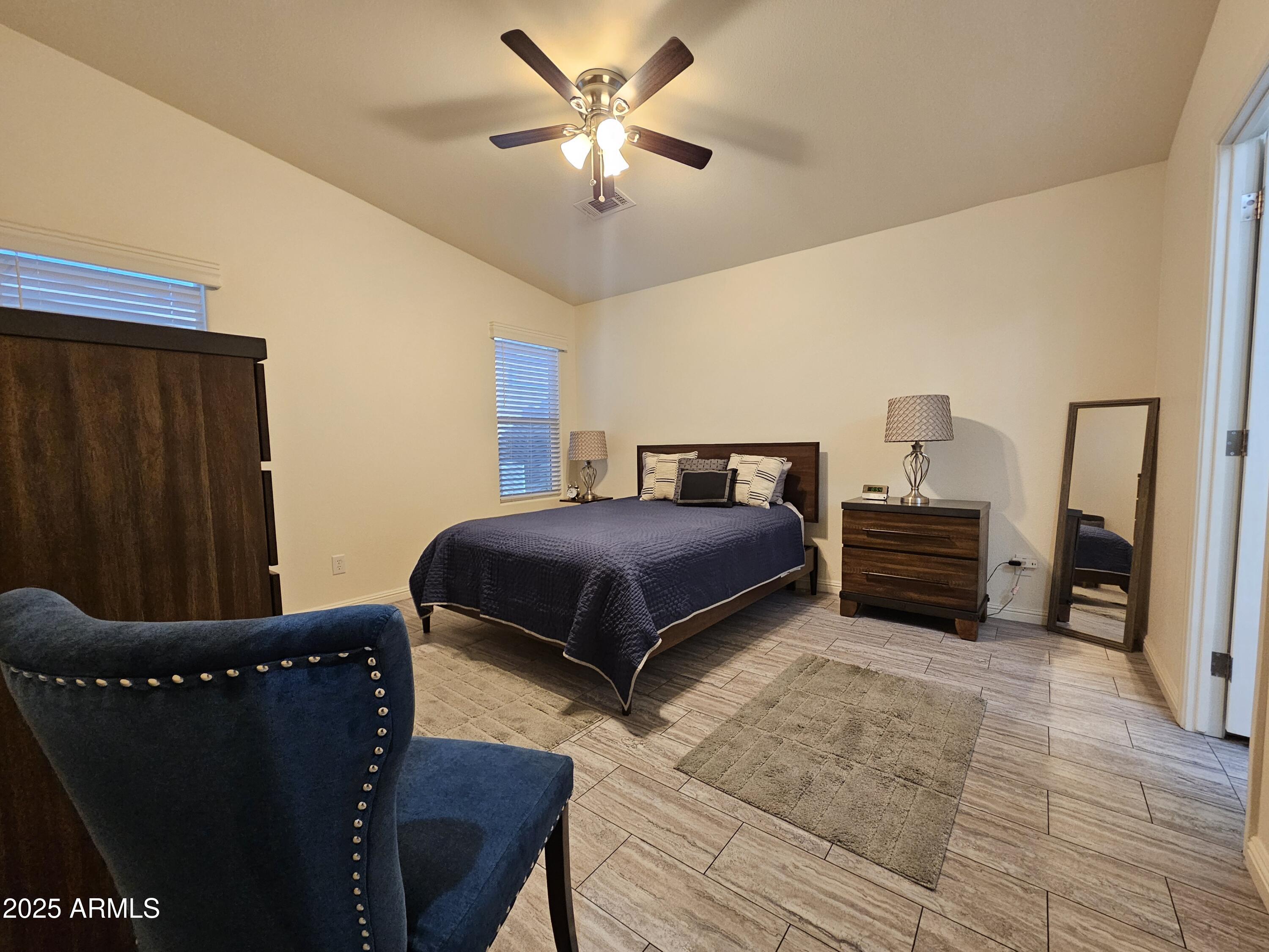 650 North Hawes Road, Unit 3124 Mesa, AZ 85207 - Photo 5 of 45 a bedroom with a bed and a chandelier