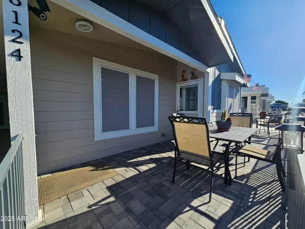 a view of a patio with table and chairs with wooden floor and fence
