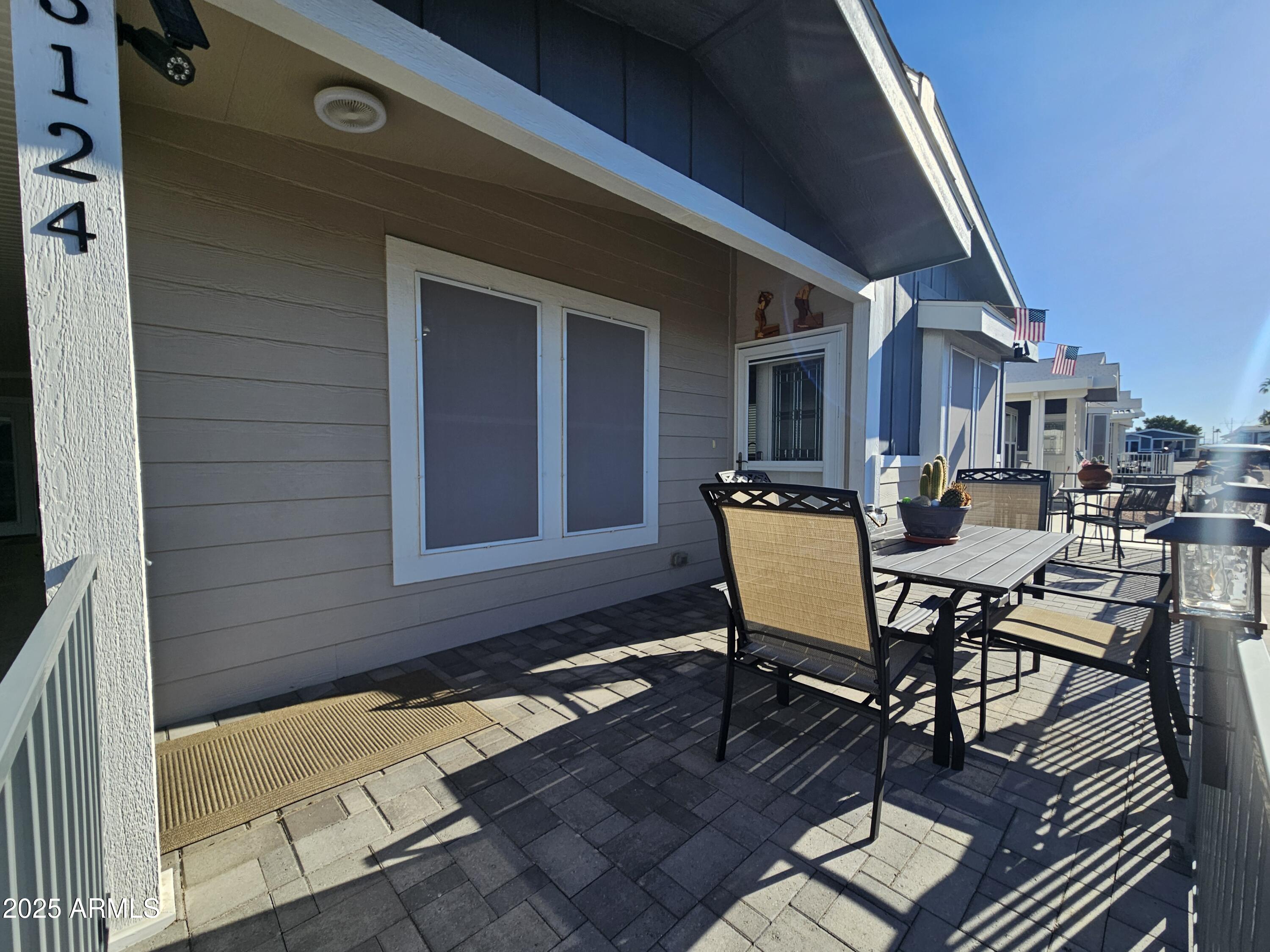 650 North Hawes Road, Unit 3124 Mesa, AZ 85207 - Photo 8 of 45 a view of a patio with table and chairs with wooden floor and fence