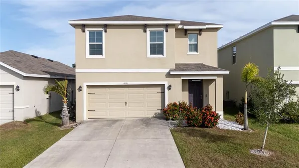 a front view of a house with a yard and garage