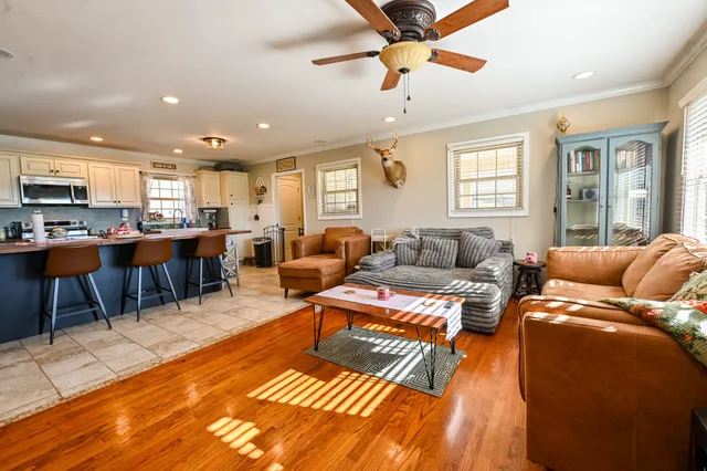 a living room with furniture kitchen view and a large window