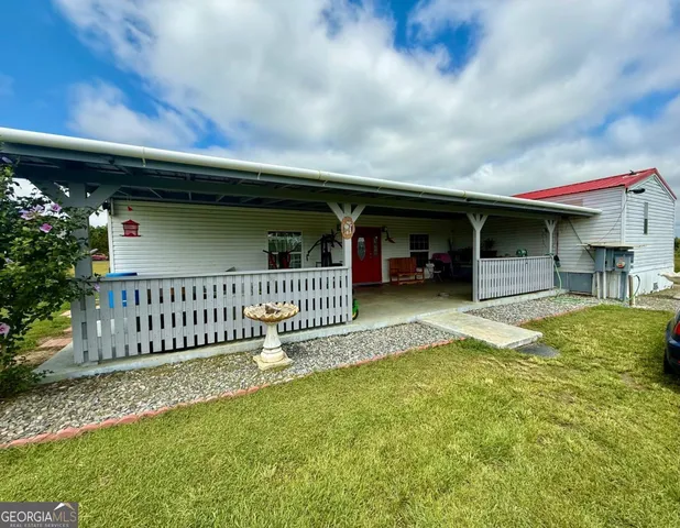 a view of a house with a yard and porch