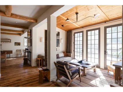 a dining room with wooden floor a chandelier a wooden table and chairs
