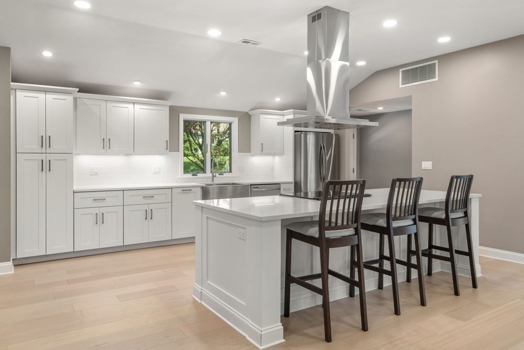 3 Emerson Road Wayland, MA 01778 - Photo 5 of 24 a kitchen with stainless steel appliances kitchen island granite countertop a table chairs sink and cabinets