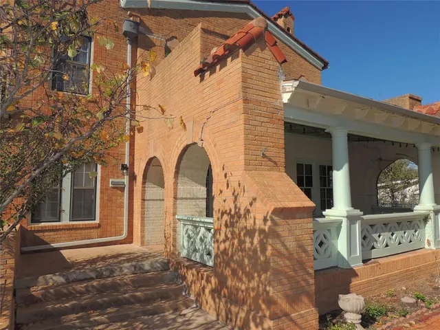 a view of a brick house with large windows