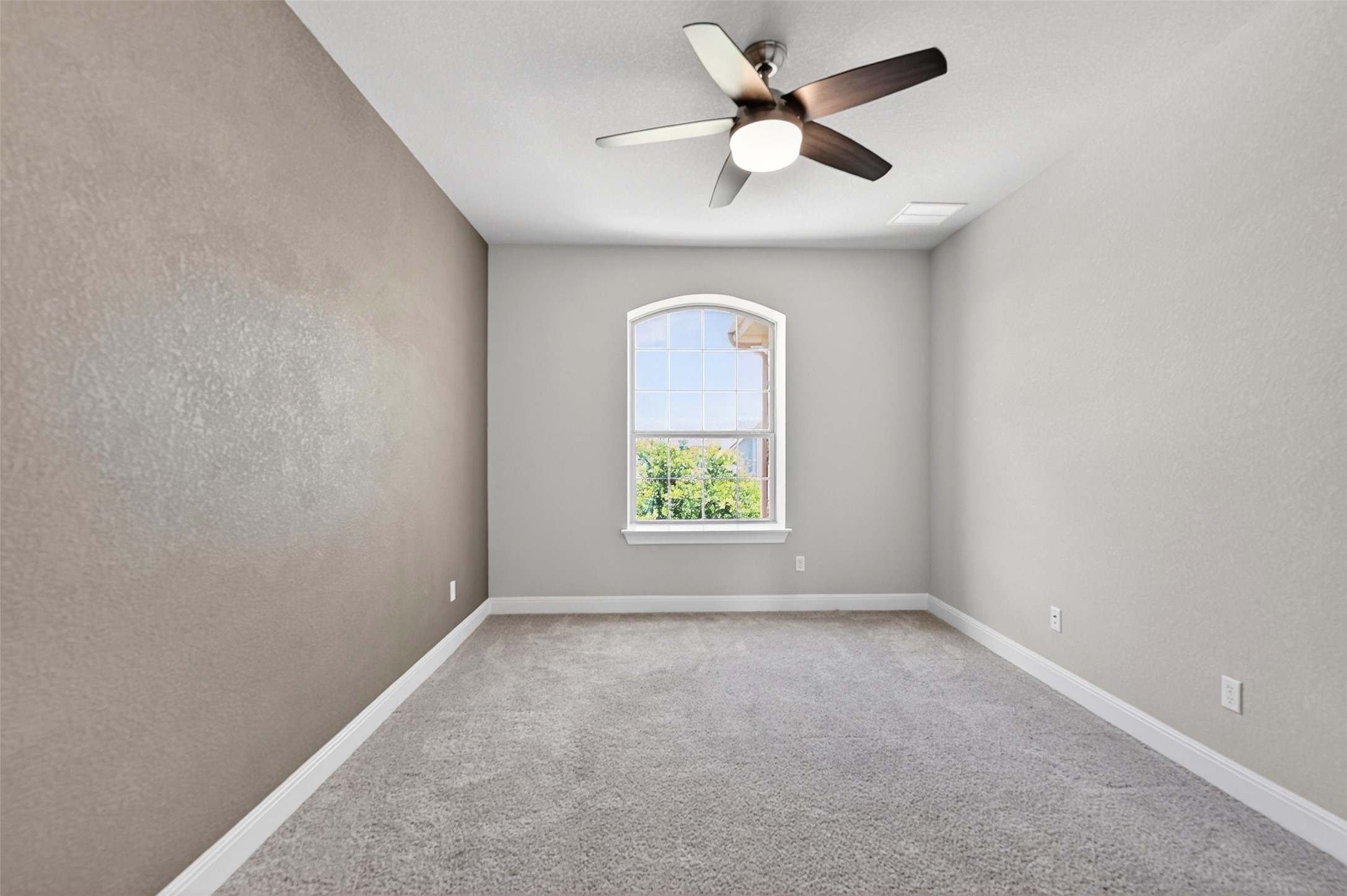 1201 Positano Pass Leander, TX 78641 - Photo 39 of 40 Carpeted room with a ceiling fan light fixture, an arched window, and two-tone wall finishes