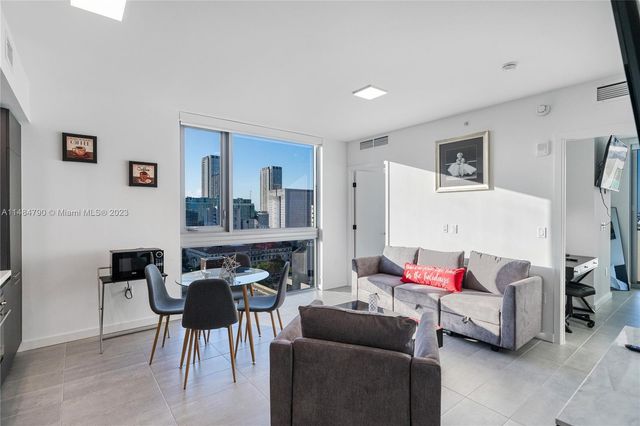 a living room with furniture and a dining table with rug