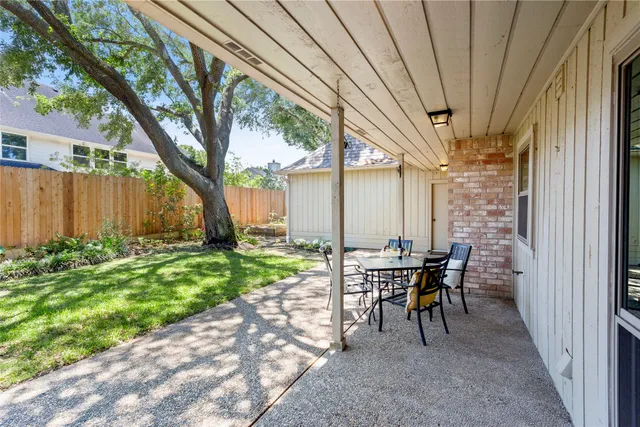 a view of a yard with wooden fence and a large tree