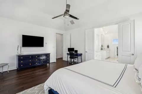a bedroom with a bed and a flat tv screen on a dresser