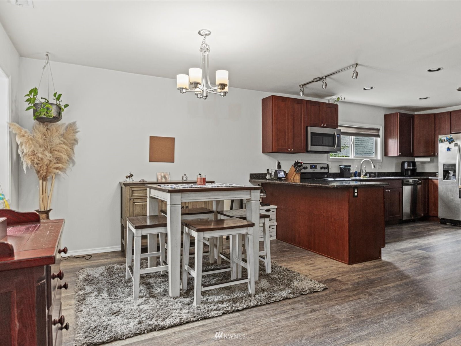 430 Southwest 4th Place Renton, WA 98057 - Photo 8 of 29 a kitchen with stainless steel appliances kitchen island granite countertop a table and chairs in it