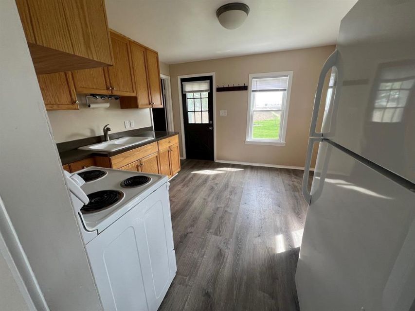 7375 Coon Trail Road Capron, IL 61012 - Photo 8 of 14 a kitchen with wooden floors and white appliances