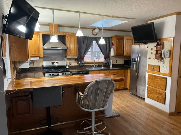 a kitchen with stainless steel appliances granite countertop a sink a stove and a refrigerator