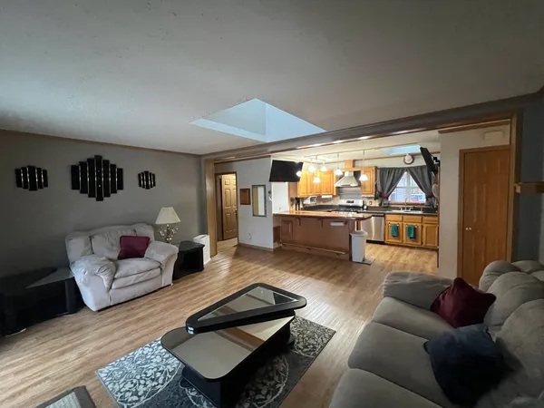 a living room with furniture and a view of kitchen