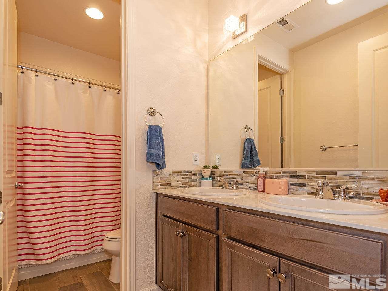 3110 Show Jumper Lane Reno, NV 89521 - Photo 27 of 28 a bathroom with a double vanity sink and a mirror