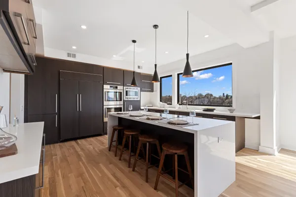 a kitchen with stainless steel appliances granite countertop a sink a stove and a refrigerator