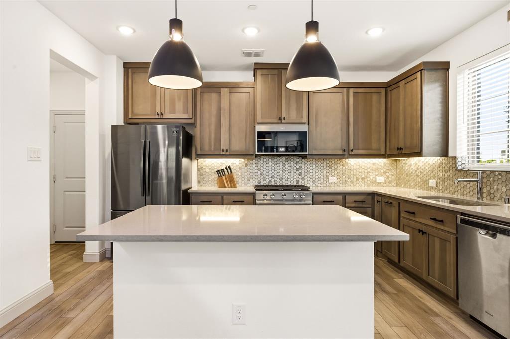 3720 Dutchess Drive Frisco, TX 75034 - Photo 13 of 36 a kitchen with stainless steel appliances a sink stove and refrigerator