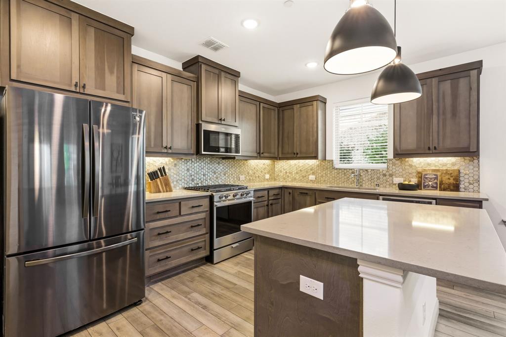 3720 Dutchess Drive Frisco, TX 75034 - Photo 2 of 36 a kitchen with kitchen island granite countertop stainless steel appliances and wooden cabinets