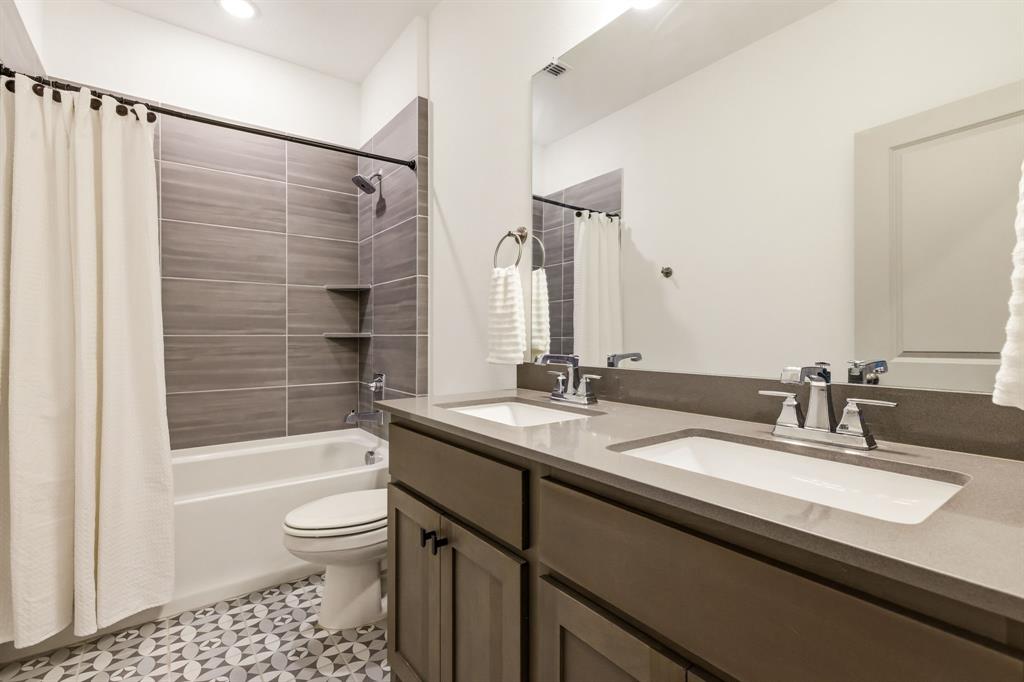 3720 Dutchess Drive Frisco, TX 75034 - Photo 25 of 36 a bathroom with a granite countertop sink a toilet a mirror a bathtub and shower