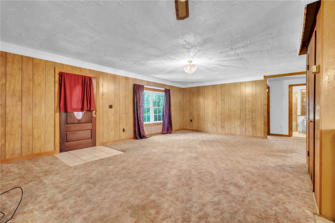 602 Harper Road Pendleton, SC 29670 - Photo 7 of 32 A spacious room offers warm wood paneling and a sparkling chandelier, ready for a personal touch.