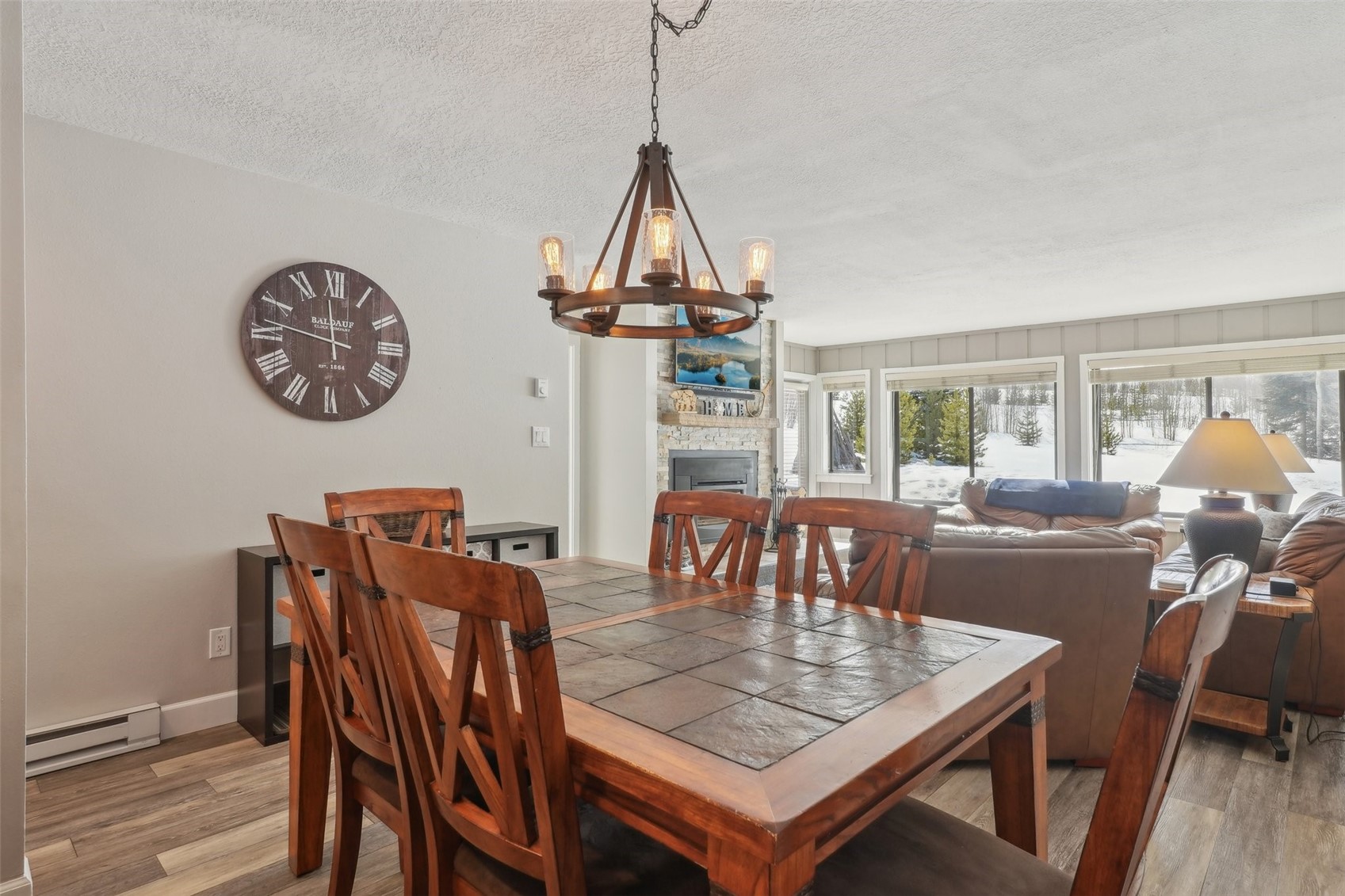 1944 Soda Ridge Road, Unit 1228 Keystone, CO 80435 - Photo 11 of 46 Dining area featuring a baseboard radiator, a notable chandelier, light wood-style flooring, and a fireplace