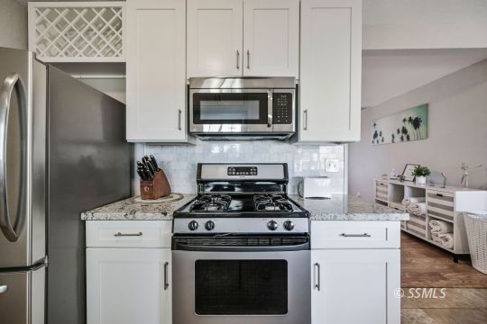 1341 Sims Street Ridgecrest, CA 93555 - Photo 5 of 27 a kitchen with stainless steel appliances white cabinets and a stove a oven