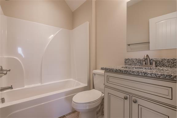 657 Jackson Road Portland, TN 37148 - Photo 24 of 30 a bathroom with a granite countertop toilet a sink and a bathtub