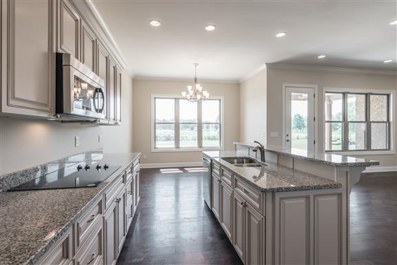 657 Jackson Road Portland, TN 37148 - Photo 9 of 30 a kitchen with granite countertop a sink stove and cabinets