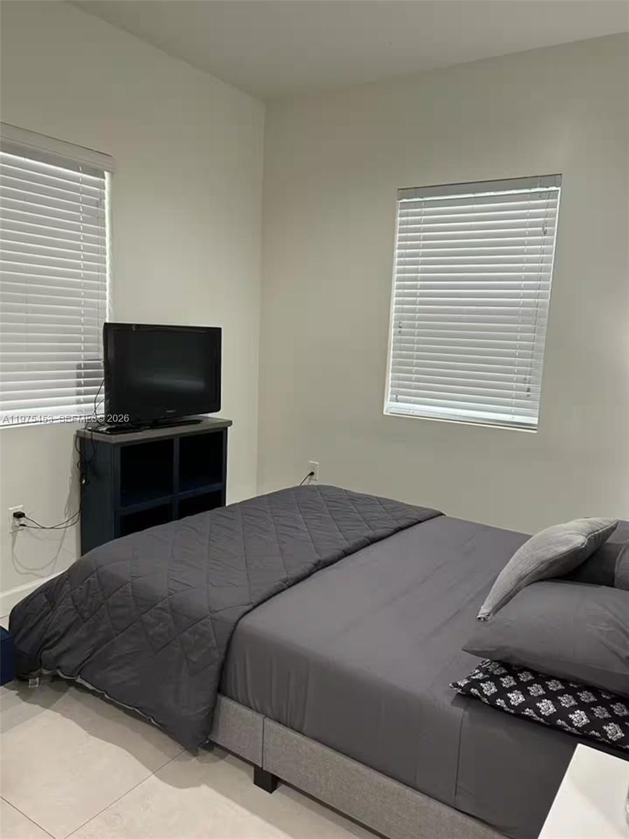 a bedroom with a bed and a television