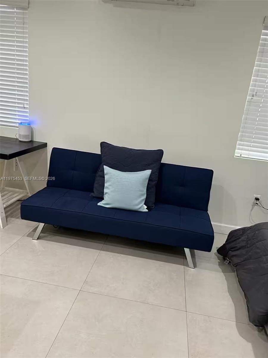 245 Northeast 33rd Street, Unit 207 Miami, FL 33137 - Photo 6 of 6 a living room with furniture and a window