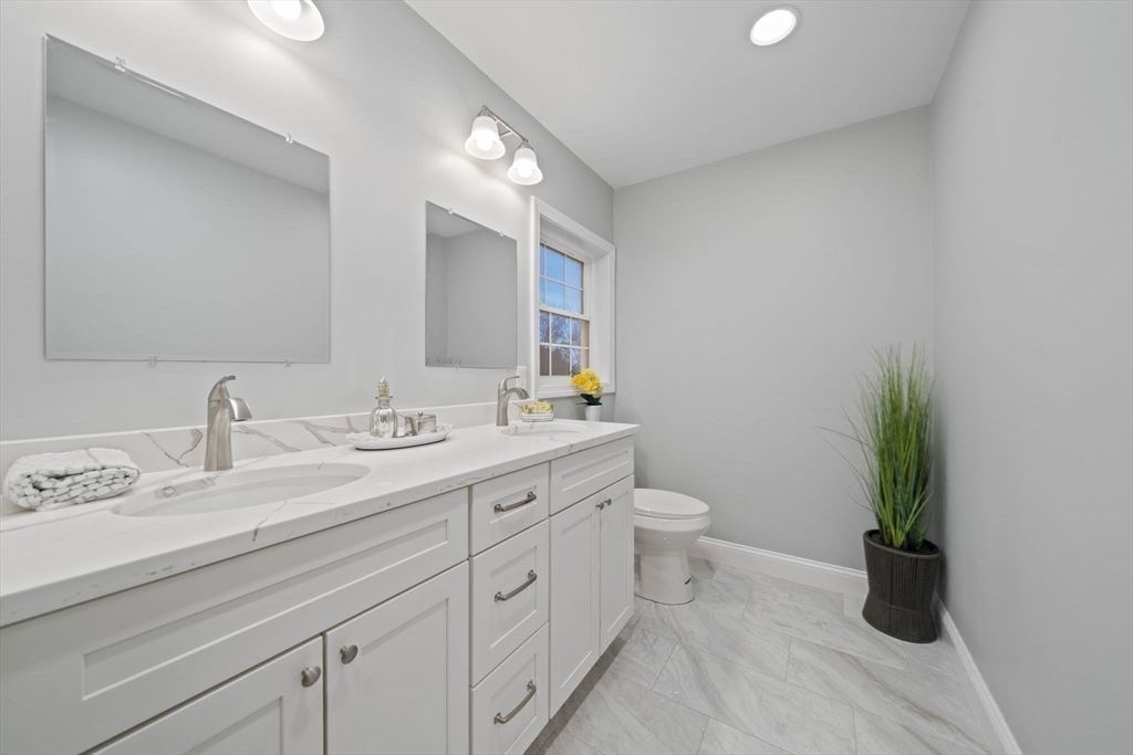 6 Simmonds Boulevard, Unit 6 Randolph, MA 02368 - Photo 12 of 28 a bathroom with a granite countertop sink a toilet and a mirror