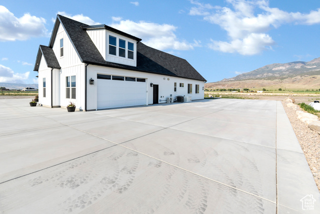 1952 Highway 118 Monroe, UT 84754 - Photo 7 of 88 View of side of property featuring a mountain view, concrete driveway, a garage, board and batten siding, and roof with shingles