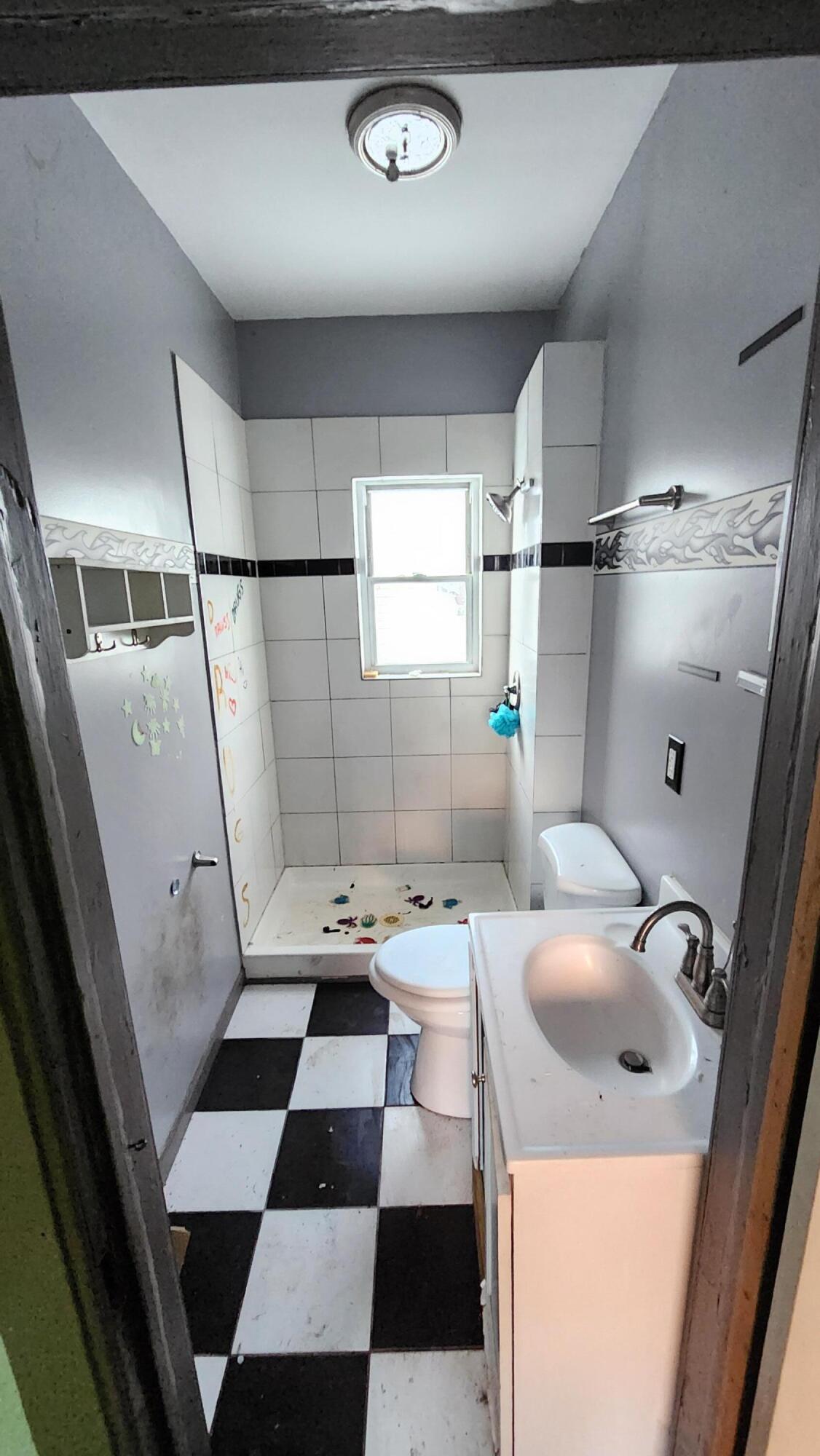 1137 Indiana Street Hammond, IN 46320 - Photo 10 of 13 a bathroom with a sink a toilet a mirror and shower