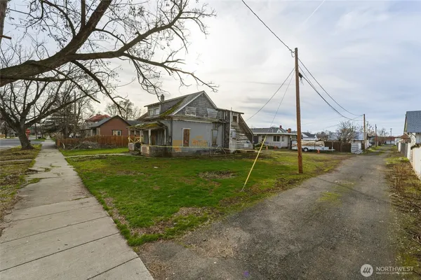 a view of a house with a big yard and potted plants