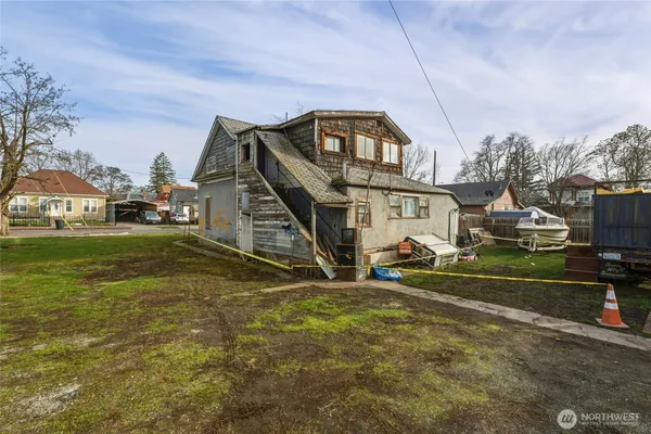 a view of a house next to a big yard with potted plants