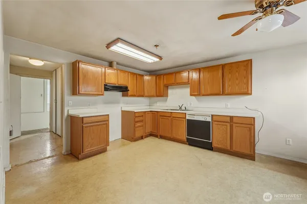 a large kitchen with stainless steel appliances granite countertop a sink a stove cabinets and wooden floor