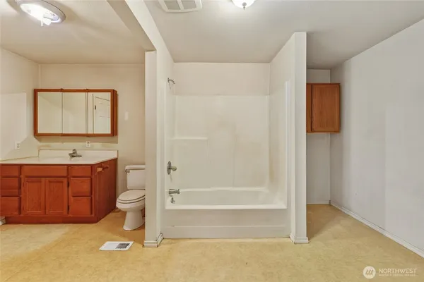 a bathroom with a granite countertop toilet sink and mirror