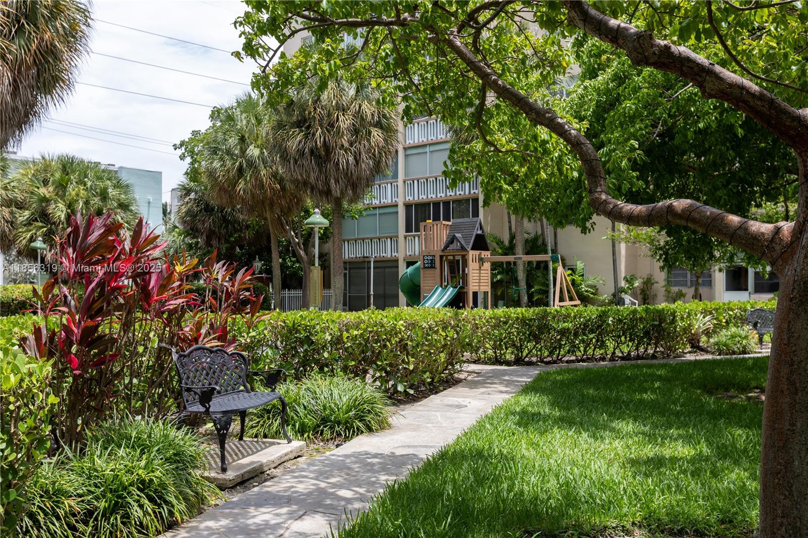 619 Northeast 14th Avenue, Unit 507 Hallandale Beach, FL 33009 - Photo 28 of 31 a front view of a house with a yard and potted plants