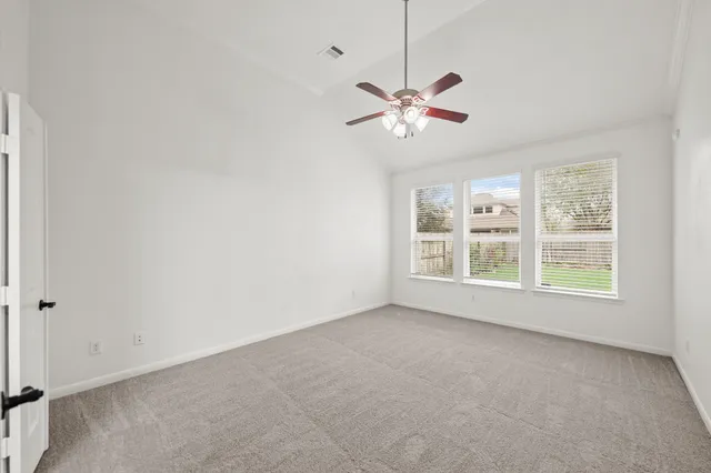 an empty room with a window and a fan