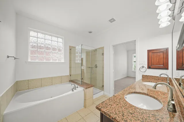 a bathroom with a granite countertop tub sink and mirror