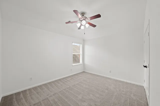 a view of a room with a ceiling fan and a window